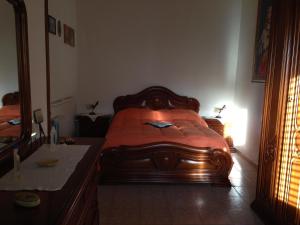 1 dormitorio con cama de madera, escritorio y espejo en Casa Vacanze Cuore del Pollino, en Viggianello