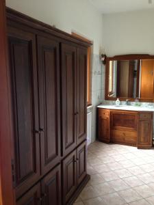 una cocina con fregadero y un gran armario de madera en Casa Vacanze Cuore del Pollino, en Viggianello