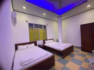 Zimmer mit 2 Betten und blauer Decke in der Unterkunft ĐÔNG NAM HOTEL CẦN THƠ in Cần Thơ