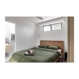 a bedroom with a bed with a green comforter at Studio On Park in Albion Park