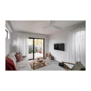 uma sala de estar com um sofá e uma televisão em Studio On Park em Albion Park