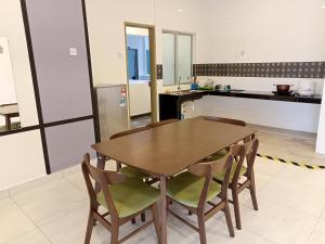 a kitchen with a wooden table and chairs at Cameron Homestay @ Quintet in Tanah Rata