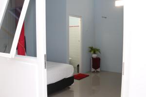 um quarto com uma cama branca e um espelho em RedDoorz Syariah near Suncity Mall Madiun em Madiun