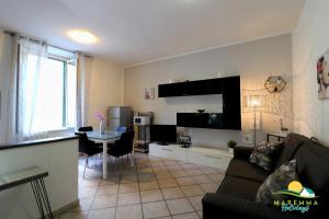 a living room with a couch and a table at Maremma Holidays-Casa Magò in Follonica