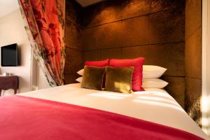 a bedroom with a bed with red and gold pillows at Hotel Frangos in Daylesford