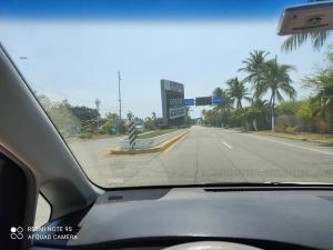 een uitzicht vanuit het voorraam van een auto die over een weg rijdt bij depto relajante Diamante in Acapulco