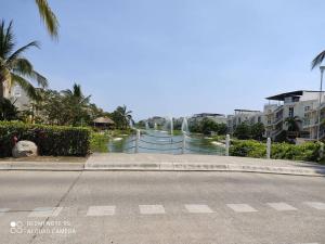 an empty street with a fence and a water fountain at depto relajante Diamante in Acapulco