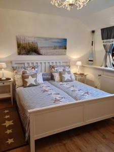 Un dormitorio con una gran cama blanca y una lámpara de araña. en Ferienwohnung op de Warft, en Neukirchen