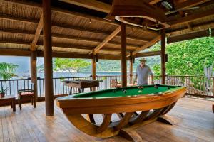 a man standing on a deck with a pool table at Six Senses Ninh Van Bay in Ninh Van Bay