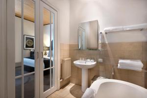 a bathroom with a sink and a tub and a toilet at Hotel Frangos in Daylesford