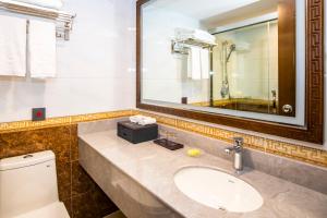 a bathroom with a sink and a mirror and a toilet at Fu Hua Hotel in Macau