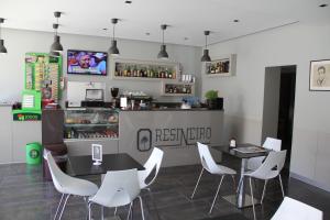 un ristorante con due tavoli e sedie bianche di Restaurante e Residencial O Resineiro a Vidago