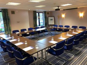 een conferentiezaal met lange tafels en blauwe stoelen bij Holiday Inn Express Poole, an IHG Hotel in Poole