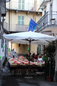 un grupo de mesas bajo una sombrilla blanca en Hotel Persico, en Saluzzo