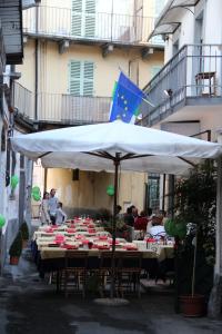 un groupe de tables sous un parapluie blanc dans l'établissement Hotel Persico, à Saluces