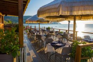 ein Restaurant am Strand mit Tischen und Sonnenschirmen in der Unterkunft saracena Holiday Home with Private Beach and Swimming Pool in Mattinata