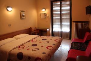 une chambre d'hôtel avec un lit et une chaise dans l'établissement Hotel Persico, à Saluces