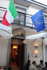 duas bandeiras estão voando sobre uma mesa em um restaurante em Hotel Persico em Saluzzo