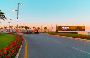 een lege straat met bloemen en een winkelcentrum bij Porto Said Resort Rentals in `Ezbet Shalabi el-Rûdi