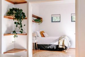 a bedroom with a bed with a plant in it at The Villa Margaret River in Margaret River Town