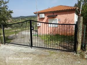 una cerca negra frente a una casa rosa en Sardinia lux house, en Sardínia