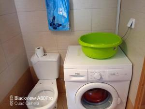 a washing machine with a green bucket on top of it at Sardinia lux house in Sardínia