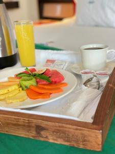 a plate of vegetables on a table with a glass of orange juice at Hotel Costa Azul in Acapulco