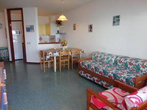 een woonkamer met een bank en een tafel bij Sea view flat just 70m from the beach in Porto Santa Margherita di Caorle