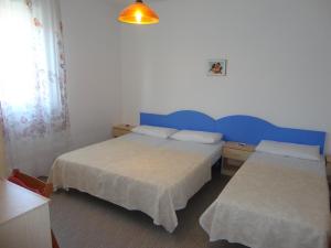 een hotelkamer met 2 bedden en een raam bij Sea view flat just 70m from the beach in Porto Santa Margherita di Caorle