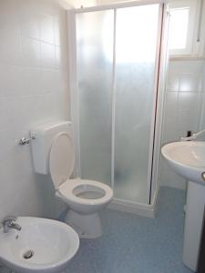 een badkamer met een toilet, een douche en een wastafel bij Sea view flat just 70m from the beach in Porto Santa Margherita di Caorle