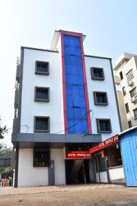 biały budynek z czerwonym i niebieskim w obiekcie Hotel Temple Sai w mieście Shirdi