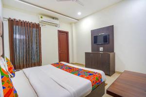 a hotel room with a bed and a tv at FabHotel Grand Inn in Jalandhar