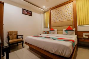 a bedroom with a bed with a chair and a window at FabHotel Baba Residency in New Delhi