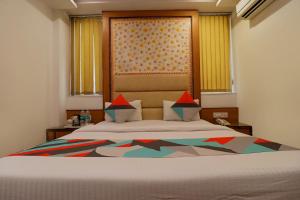 a bedroom with a large bed with a large window at FabHotel Baba Residency in New Delhi