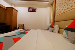 een slaapkamer met een groot wit bed in een kamer bij FabHotel Baba Residency in New Delhi