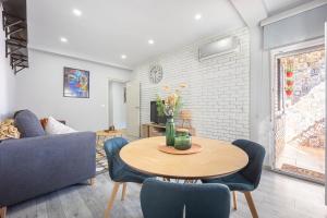 uma sala de estar com mesa e cadeiras em Delagua Apartments Atocha I em Madri