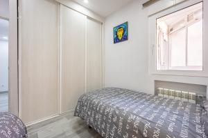 um quarto com uma cama e uma janela em Delagua Apartments Atocha I em Madri