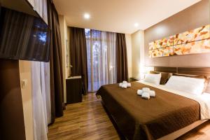 Un pat sau paturi într-o cameră la Sani Apart Hotel