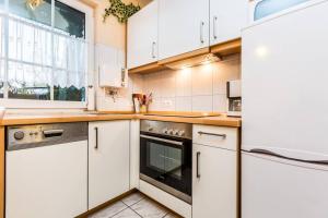 a white kitchen with white cabinets and a window at Apartment in Bergisch Gladbach in Bergisch Gladbach