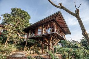 una casa en el árbol con una terraza encima en Grün Ubud, en Ubud