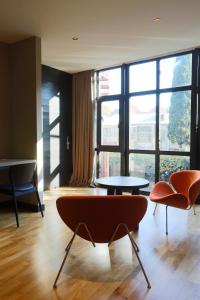 une chambre avec deux chaises, une table et des fenêtres dans l'établissement Hotel Zeg, à Tbilissi