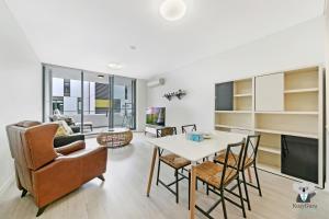 a living room with a table and chairs at KOZYGURU MASCOT 2 BED APT FREE DOUBLE-PARKING NMA629 in Sydney