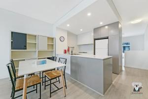 a kitchen and dining room with a table and chairs at KOZYGURU MASCOT 2 BED APT FREE DOUBLE-PARKING NMA629 in Sydney