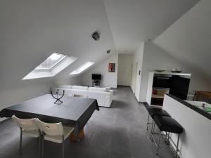 Boevange-sur-Attert的住宿－COSYLOFT APARTMENT，厨房以及带桌椅的起居室。