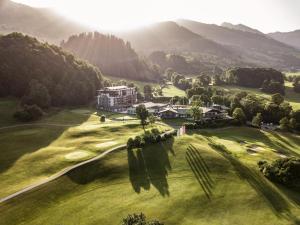 uma vista aérea de um campo de golfe com montanhas ao fundo em Grand Tirolia Kitzbühel - Member of Hommage Luxury Hotels Collection em Kitzbühel