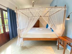 a bed in a room with a mosquito net at Unawatuna Nor Lanka Hotel in Unawatuna