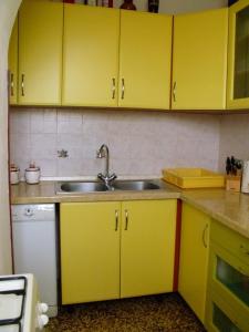 una cocina con armarios amarillos y fregadero en Apartments Cerin, en Fažana