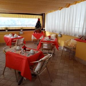 a restaurant with tables with red table cloths and a christmas tree at B&B La Cupella in Monterotondo