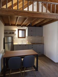 a kitchen with a wooden table and two chairs at Olympus Country House in Kariá