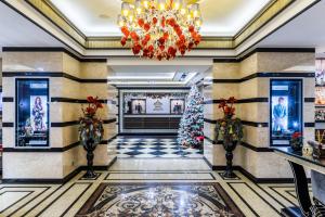 een kerstboom in een lobby met een kroonluchter bij Majestic Boutique Hotel Deluxe in Sint-Petersburg